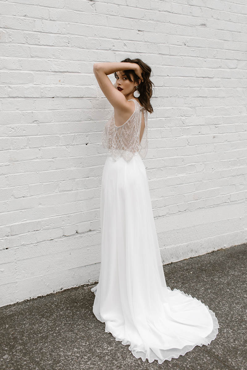 This fun sexy two piece wedding dress is a combination of a beaded top with a scalloped hem, high-neckline & open back and seperate soft chiffon skirt.