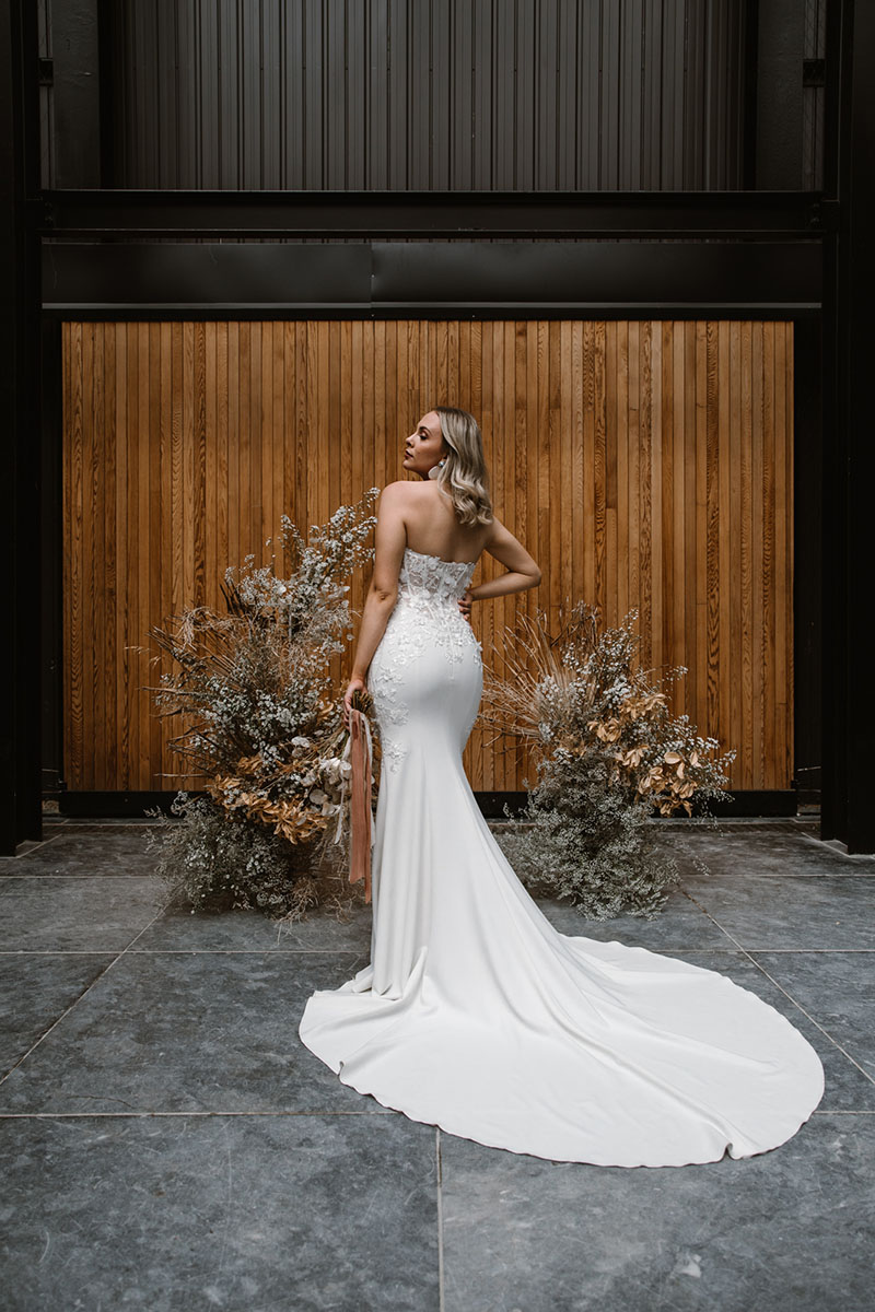 A sheer, 3D lace bodice – accented perfectly with a sweetheart neckline – and simple crepe trumpet skirt sets the stage for this mermaid wedding gown.