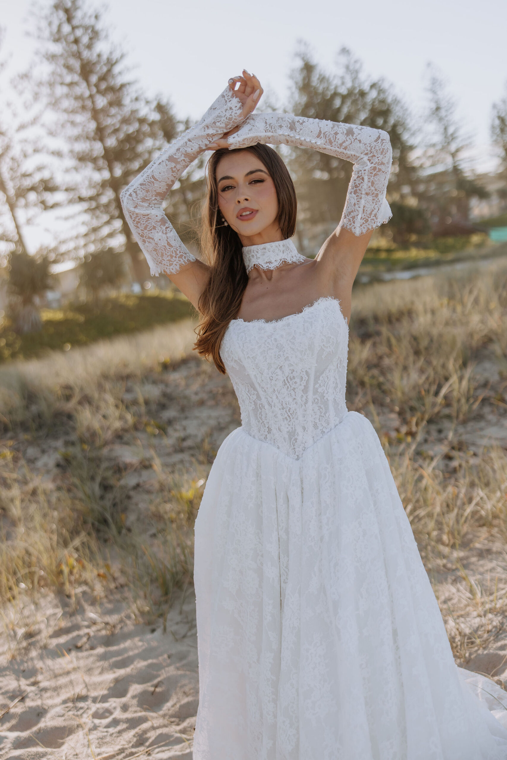 The mermaid off the shoulder silhouette of our Paloma wedding dress enhances your curves with the artful placement of the leafy vine lace applique design.